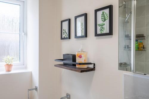 a bathroom with a shower and a soap bottle on a shelf at Close to Warwick University - Clover Way by Tŷ SA in Canley