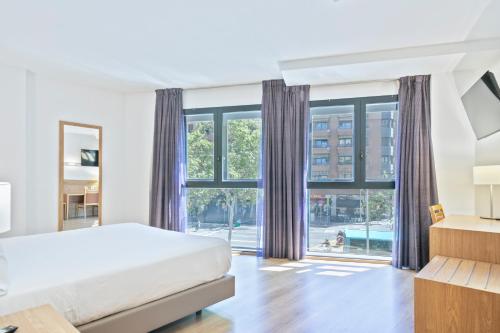 a bedroom with a bed and a large window at Hotel Acta Azul Barcelona in Barcelona