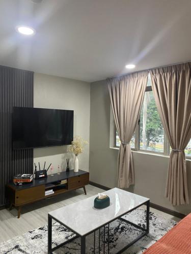 a living room with a tv and a coffee table at 1st inn hotel subang in Subang Jaya