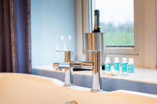 a sink with a faucet next to a window at Springfield Hotel & Health Club in Halkyn