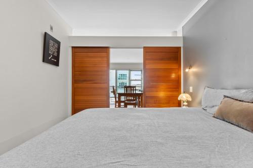 a bedroom with a bed and a dining room at Metro Retreat - Auckland Central Apartment in Auckland
