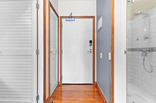 a bathroom with a shower and a white door at Metro Retreat - Auckland Central Apartment in Auckland