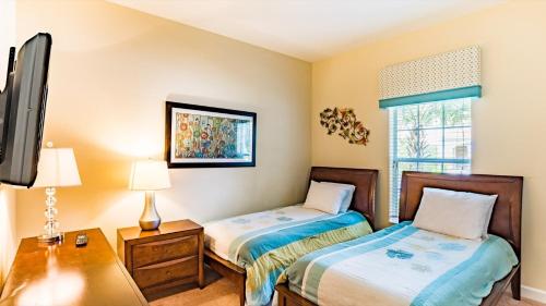 a bedroom with two beds and a tv in it at Top Villas - Paradise Palms Resort 277 in Kissimmee