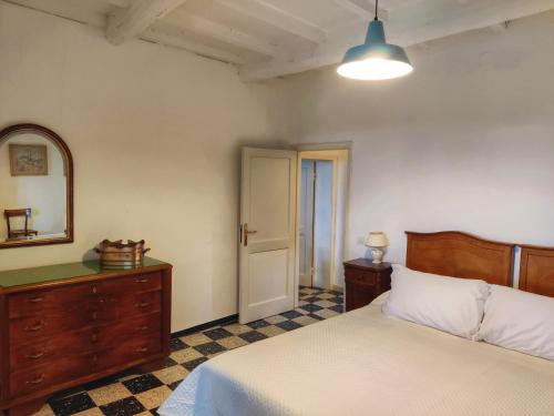 a bedroom with a bed and a dresser and a mirror at Borgo La Torre alle Tolfe in Siena