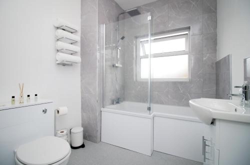 biała łazienka z toaletą i umywalką w obiekcie Parkview by Tŷ SA - spacious 3 bed in Newport w mieście Newport