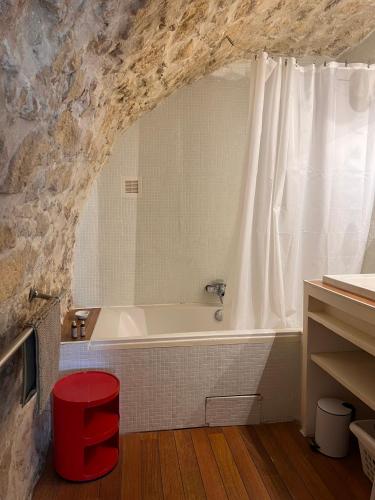 La salle de bains est pourvue d'une baignoire dans un mur en pierre. dans l'établissement Appartement Typique in Provencal village Menerbes, à Ménerbes