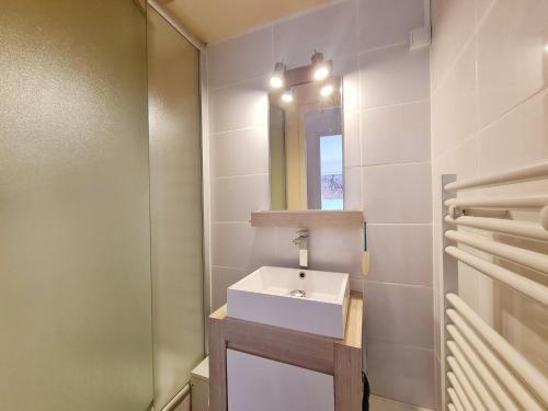 une salle de bain avec un lavabo blanc et un miroir dans l'établissement Ref 027 A louer maison pour huit personnes jardin et accès plage, à Arzon