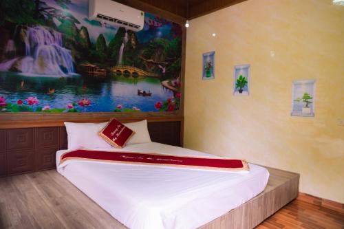 a bed in a room with a painting on the wall at Trang An Hometown Homestay in Ninh Binh