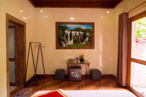 a room with a painting on the wall and a table at Trang An Hometown Homestay in Ninh Binh