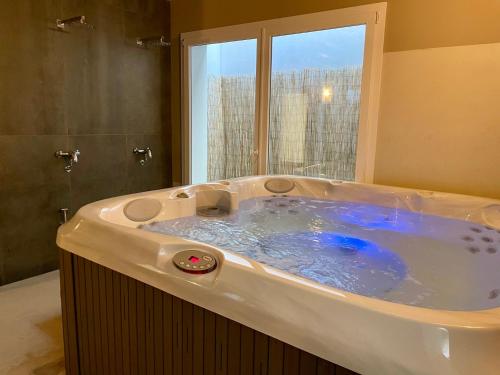 a large tub in a bathroom with a window at Relais Fontana Rosa B&B Wellness in Caprino Veronese