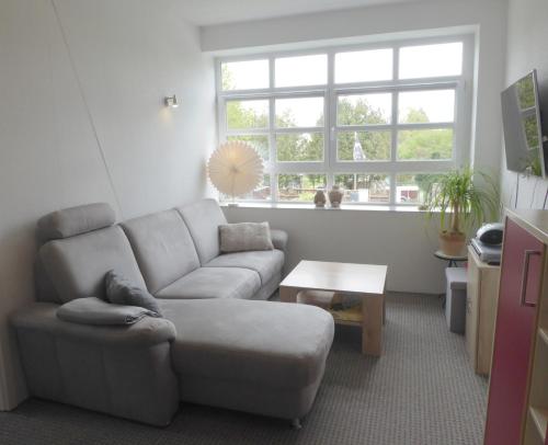 ein Wohnzimmer mit einem Sofa und einem Tisch in der Unterkunft App. Weisses Haus in Hohen Neuendorf