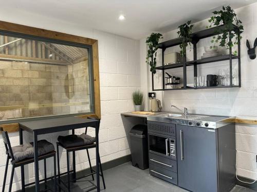 a kitchen with a sink and a counter with stools at Sleep next to a Horse in a stable by the city ! in Exeter
