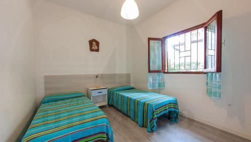 - une chambre avec 2 lits et une fenêtre dans l'établissement Bungalow Dancalia, à Eraclea Mare