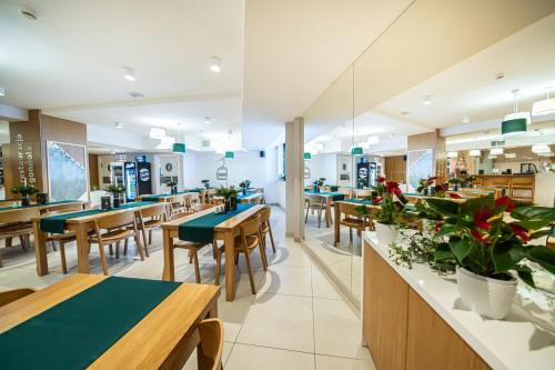 restauracja z drewnianymi stołami, krzesłami i roślinami w obiekcie Hotel Jaworzyna Krynicka w mieście Krynica Zdrój