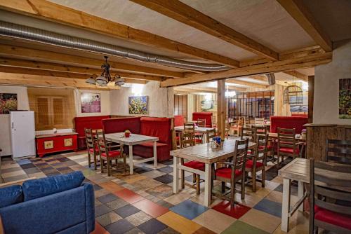 een restaurant met tafels en stoelen en rode cabines bij Folwark Malinowy Chruśniak in Bisztynek