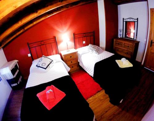 two beds in a room with red walls at Casa La Charca 