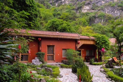 a small red house with a garden in front of it at Trang An Hometown Homestay in Ninh Binh