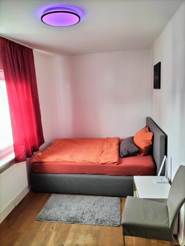 a bedroom with a bed with a red blanket at Ferienwohnung Rhein-Main II in Flörsheim