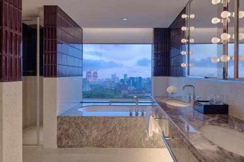 La salle de bains est pourvue de 2 lavabos et d'une grande fenêtre. dans l'établissement Hyatt Centric Zhongshan Park Shanghai, à Shanghai
