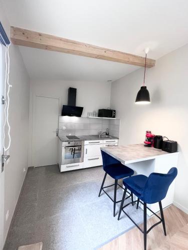 une cuisine avec une table et deux chaises bleues dans l'établissement Studio, à Vitry-sur-Seine