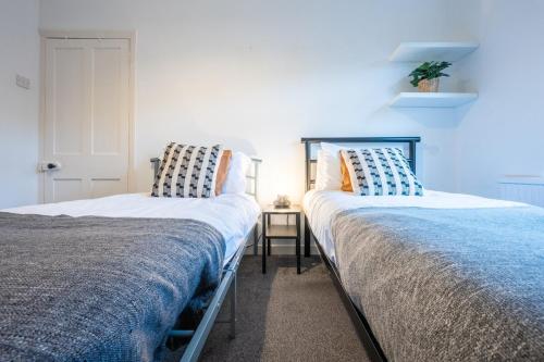 dos camas sentadas una al lado de la otra en un dormitorio en Dos Road by Tŷ SA en Newport