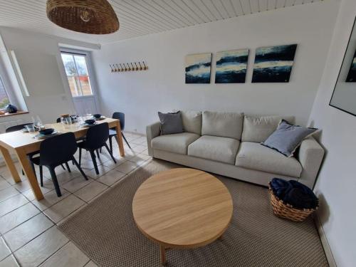 un salon avec un canapé et une table dans l'établissement Gite plages du débarquement, à La Cambe