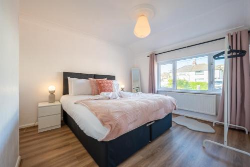 a bedroom with a large bed and a window at Rogerstone House by Tŷ SA in Rogerstone