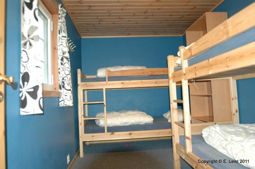two bunk beds in a room with blue walls at Skottevik Feriesenter in Skottevik