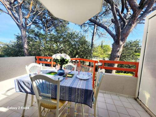 une table avec un vase de fleurs sur un balcon dans l'établissement Quercus YourHostHelper, à Saint-Raphaël