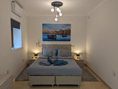 a bedroom with a bed and a painting on the wall at Modern & Cosy 1 Bed Maisonette - Close to Salina Bay in St. Paul's Bay