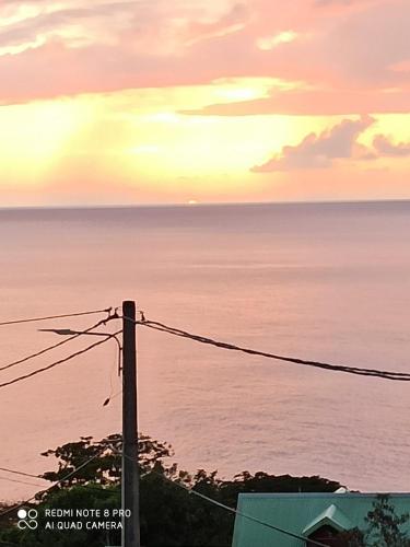 a sunset over the ocean with a telephone pole at Lacazavanoo in Baillif