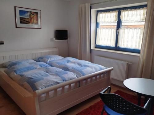 a bedroom with a bed and a table and a window at Holzhausidylle am Steimel in Neunkirchen