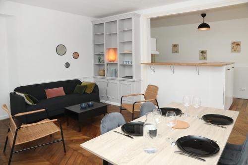 - un salon avec une table et un canapé dans l'établissement Appartement Le Saint-Pierre by La Boîte En Plus, à Senlis