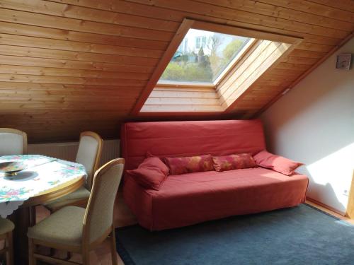 a red couch in a room with a window at Holzhausidylle am Steimel in Neunkirchen