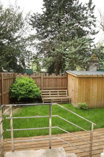 une clôture en bois avec bancs dans une cour dans l'établissement Appartement Le Saint-Pierre by La Boîte En Plus, à Senlis