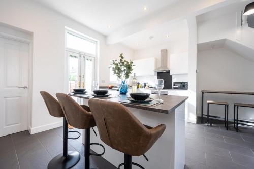 a kitchen with a table with chairs and a fireplace at Durham View by Tŷ SA in Newport