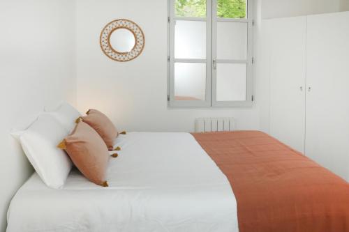 - une chambre avec un lit blanc avec des oreillers et une fenêtre dans l'établissement Appartement Le Saint-Pierre by La Boîte En Plus, à Senlis