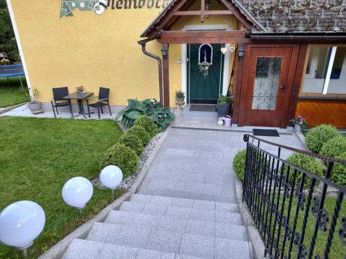 une maison avec des ballons blancs sur la pelouse dans l'établissement Apartments Haus Steinbock, à Tauplitz