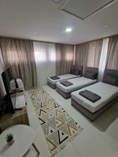 een woonkamer met twee bedden en een tafel bij Apartments Natural and Bungalows in Sarajevo