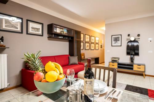 a table with a bowl of fruit and a bottle of wine at "Once Upon A Time" Cherubini Palace Thematic Apartments Free Parking in Florence
