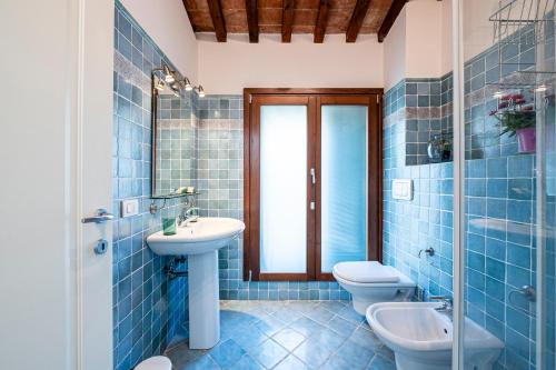 a blue tiled bathroom with two toilets and a sink at "Once Upon A Time" Cherubini Palace Thematic Apartments Free Parking in Florence