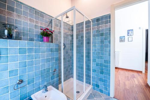a blue tiled bathroom with a shower and a sink at "Once Upon A Time" Cherubini Palace Thematic Apartments Free Parking in Florence