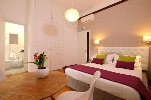 ein Schlafzimmer mit einem Bett und einem Tisch sowie ein Badezimmer in der Unterkunft Tata B&B in Rom