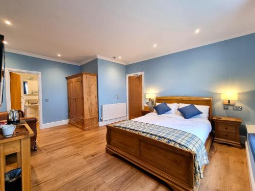 a bedroom with a large bed with blue walls at Min y Don Llandudno in Llandudno
