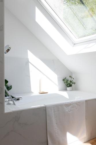 a bathroom with a white sink and a window at Chez Manou, appt spacieux et élégant proche mer in Ault