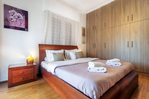 ein Schlafzimmer mit einem großen Bett mit zwei Handtüchern darauf in der Unterkunft Gazi apartment with Acropolis views in Athen