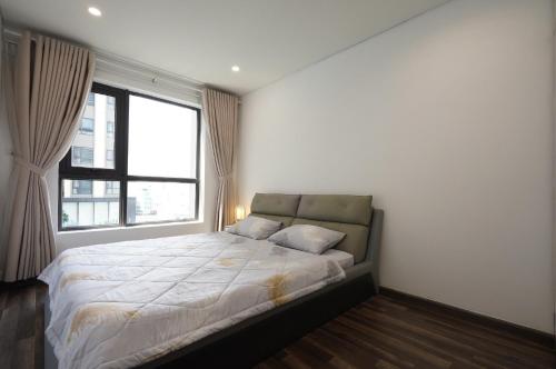 a bedroom with a bed and a large window at Aparment Hà Đô Centrosa in Ho Chi Minh City