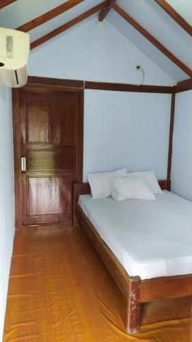 Schlafzimmer mit einem Bett und Holzboden in der Unterkunft de Travelodge Homestay 