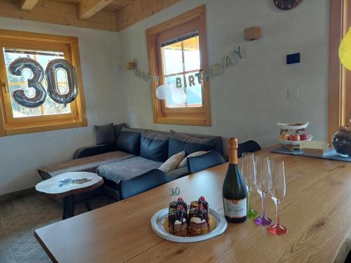 a living room with a couch and a table with a bottle of wine at Cottage Osojnik - Alpine escape with Wellness in Solčava