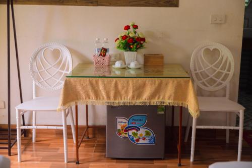 a table with two white chairs and a table with a table sidx sidx at Trang An Hometown Homestay in Ninh Binh